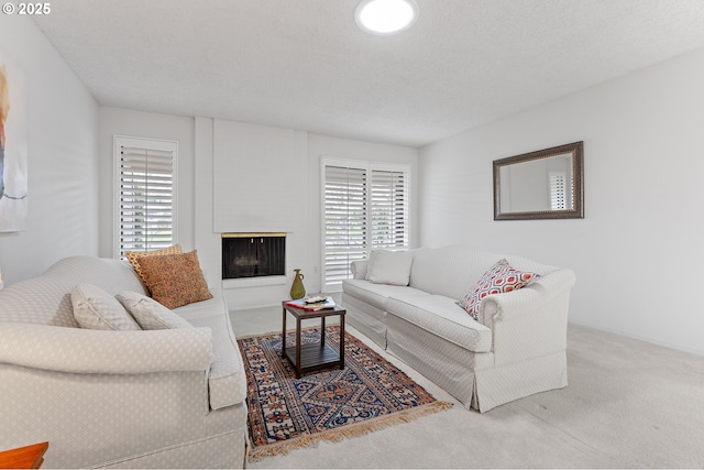 living room featuring a fireplace, carpet floors, and a textured ceiling