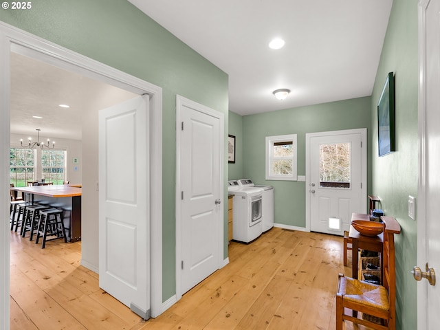 92041 Carmen Creek Rd, Astoria, OR 97103 - clothes washing area featuring washer and clothes dryer, a chandelier, light wood-type flooring, baseboards, and recessed lighting