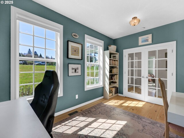 92041 Carmen Creek Rd, Astoria, OR 97103 - home office featuring french doors, hardwood / wood-style floors, and baseboards
