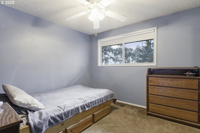 bedroom featuring a textured ceiling, baseboards, a ceiling fan, and carpet