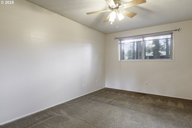 empty room with a textured ceiling, a ceiling fan, and carpet