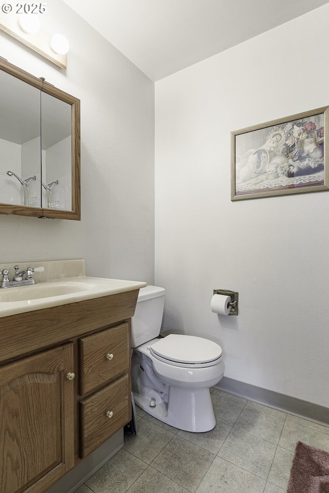 bathroom featuring tile patterned floors, toilet, vanity, and baseboards