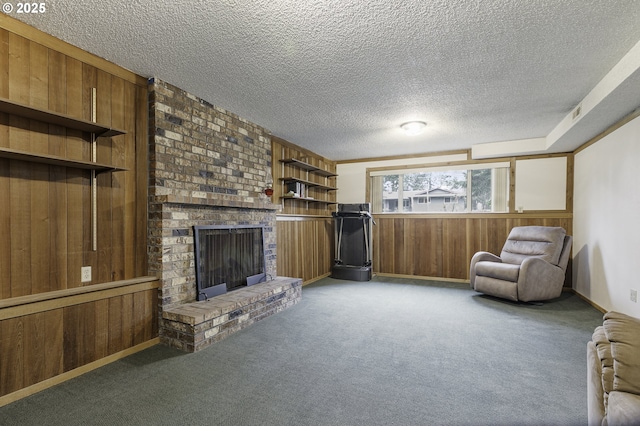 interior space with a textured ceiling, wood walls, a fireplace, and carpet floors