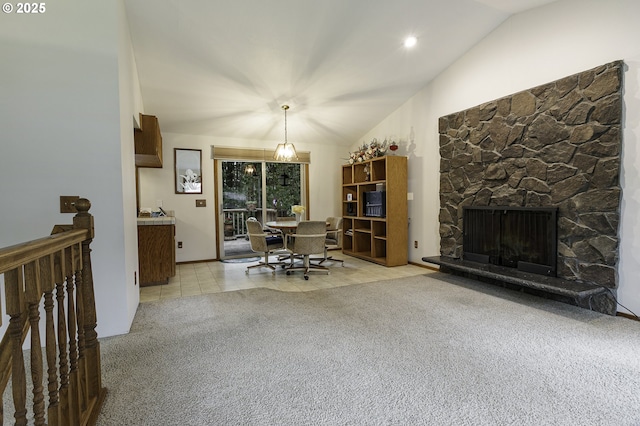 office with light colored carpet, a stone fireplace, vaulted ceiling, and light tile patterned floors