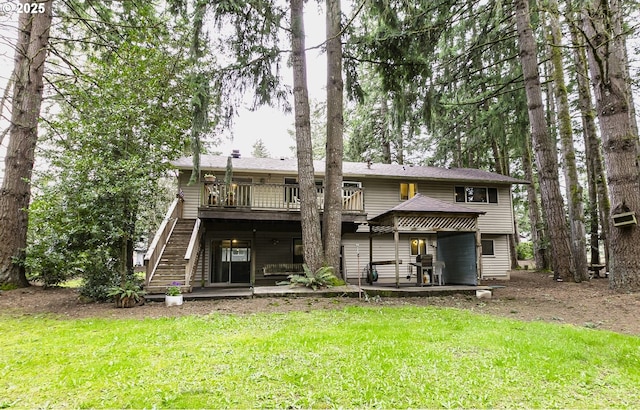 rear view of house featuring stairs, a deck, and a lawn