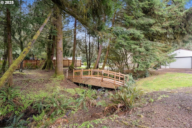 surrounding community featuring a garage, a deck, fence, and an outbuilding