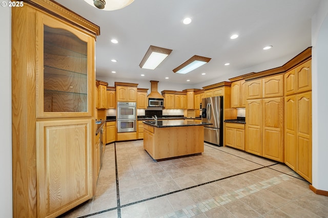 kitchen featuring recessed lighting, a kitchen island, dark countertops, stainless steel appliances, and a sink