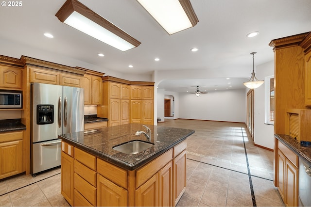kitchen with recessed lighting, ceiling fan, stainless steel appliances, arched walkways, and a sink