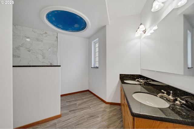 bathroom featuring a sink, baseboards, and double vanity