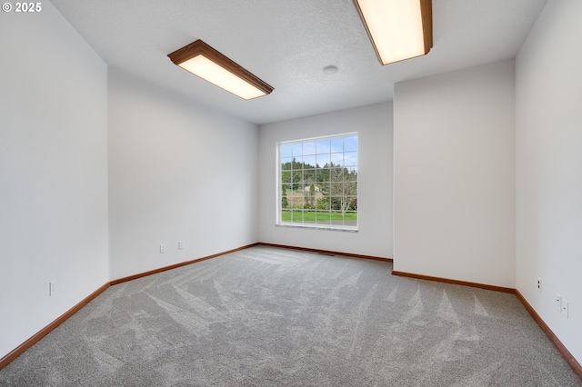 carpeted empty room featuring baseboards