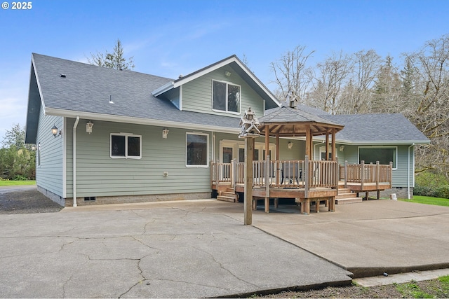 back of house featuring roof with shingles and crawl space