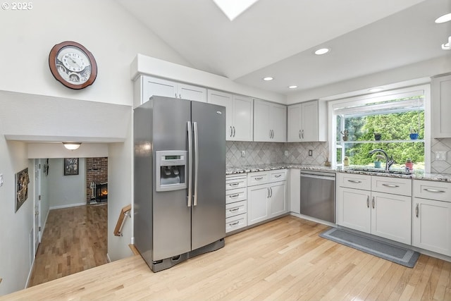 16485 SW Viking Ct, Beaverton, OR 97007 - kitchen featuring appliances with stainless steel finishes, light wood-style flooring, backsplash, vaulted ceiling, and recessed lighting