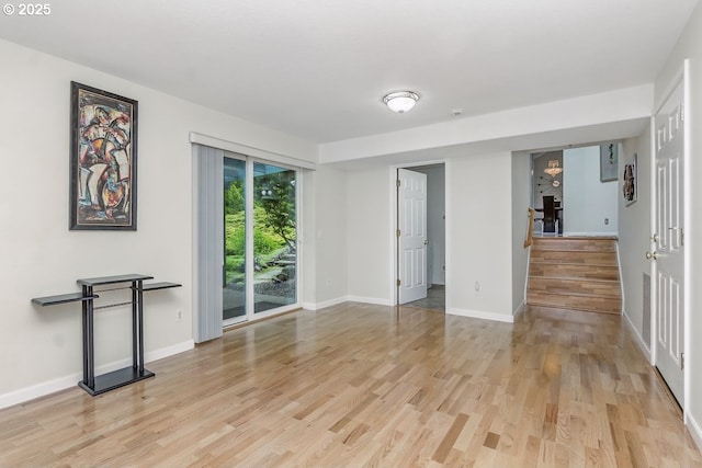 16485 SW Viking Ct, Beaverton, OR 97007 - unfurnished living room with light wood finished floors, stairway, and baseboards