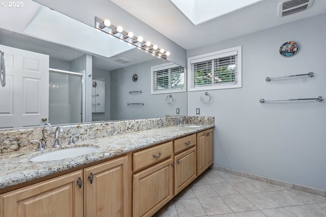 16485 SW Viking Ct, Beaverton, OR 97007 - bathroom with double vanity, a stall shower, baseboards, tile patterned floors, and a skylight