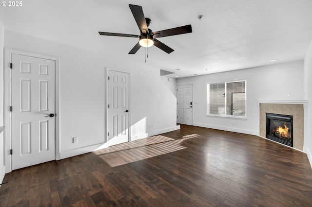 unfurnished living room with a fireplace, ceiling fan, and dark wood-type flooring