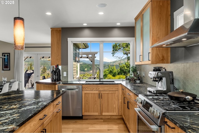 1524 Sherman Ave, Hood River, OR 97031 - kitchen featuring wall chimney range hood, stainless steel appliances, a sink, dark stone countertops, and light wood-style flooring