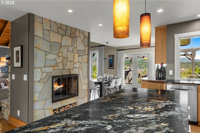 1524 Sherman Ave, Hood River, OR 97031 - kitchen featuring stainless steel dishwasher, a stone fireplace, plenty of natural light, recessed lighting, and decorative backsplash