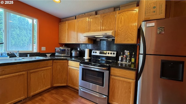 2113 SE 181st Ave, Vancouver, WA 98683 - kitchen featuring appliances with stainless steel finishes, under cabinet range hood, a sink, wood finished floors, and tasteful backsplash
