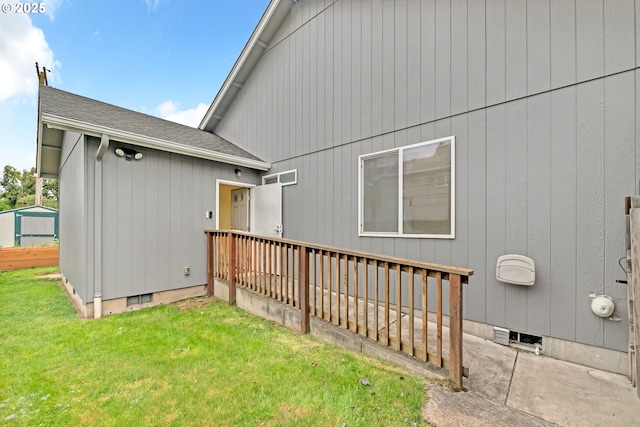 rear view of property with a lawn, crawl space, a shingled roof, and a wooden deck
