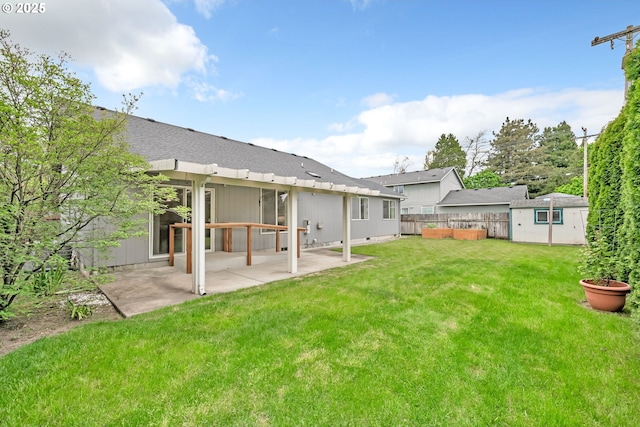 rear view of property with a patio, a lawn, fence, and an outbuilding