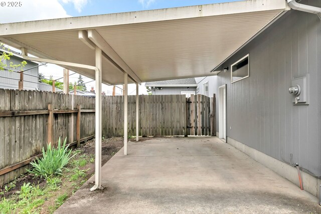 view of patio featuring fence and a carport