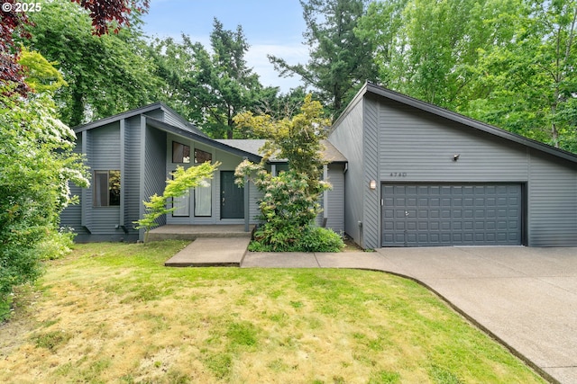 4740 SW Lowell Ct, Portland, OR 97221 - mid-century inspired home with concrete driveway, a garage, and a front lawn
