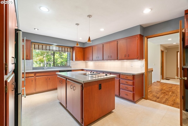 4740 SW Lowell Ct, Portland, OR 97221 - kitchen with black electric stovetop, a kitchen island, recessed lighting, tasteful backsplash, and light flooring