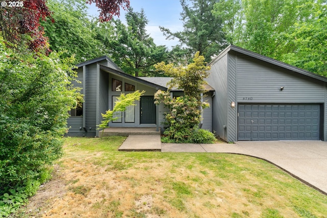 4740 SW Lowell Ct, Portland, OR 97221 - mid-century home featuring concrete driveway, a garage, and a front yard