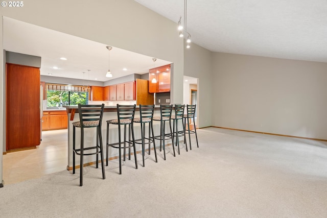 4740 SW Lowell Ct, Portland, OR 97221 - kitchen featuring a peninsula, a breakfast bar area, light carpet, recessed lighting, and pendant lighting
