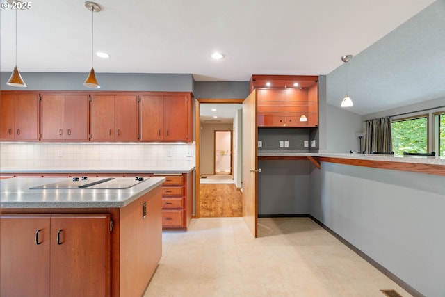4740 SW Lowell Ct, Portland, OR 97221 - kitchen with black electric stovetop, backsplash, decorative light fixtures, brown cabinets, and recessed lighting