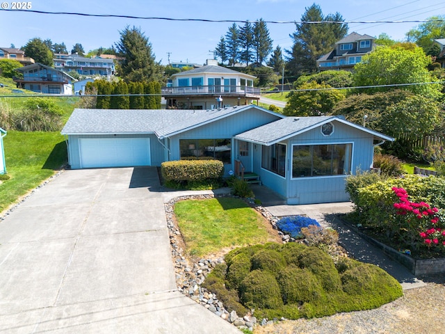 35565 Lower Loop Rd, Pacific City, OR 97135 - view of front of home with concrete driveway, an attached garage, and a front lawn