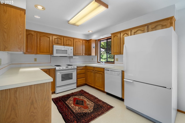 35565 Lower Loop Rd, Pacific City, OR 97135 - kitchen featuring white appliances, a sink, brown cabinetry, light countertops, and recessed lighting