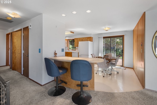 35565 Lower Loop Rd, Pacific City, OR 97135 - kitchen featuring white appliances, brown cabinets, a kitchen breakfast bar, recessed lighting, and light countertops