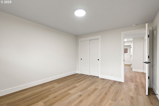 unfurnished bedroom with a closet and light hardwood / wood-style flooring