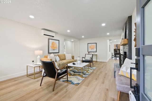 living room with light hardwood / wood-style floors, a wall mounted AC, and a brick fireplace