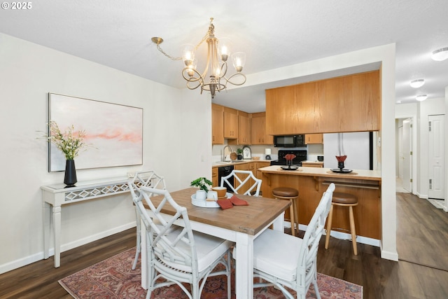 16146 SW 130th Ter Unit 2, Portland, OR 97224 - dining space featuring a chandelier, dark wood-type flooring, and baseboards