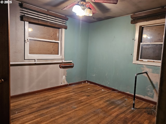 spare room featuring a ceiling fan, wood finished floors, and baseboards