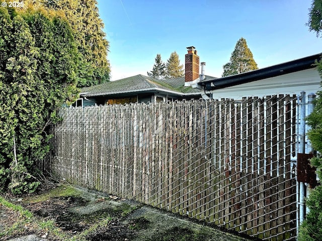 view of home's exterior featuring a chimney and fence