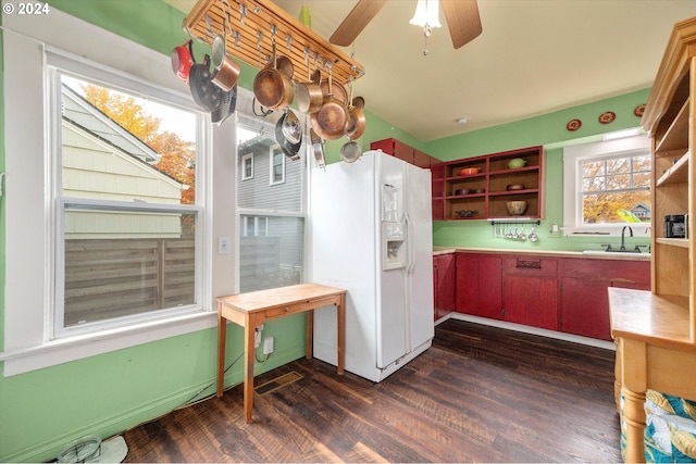kitchen featuring a sink, white refrigerator with ice dispenser, open shelves, and dark wood-type flooring