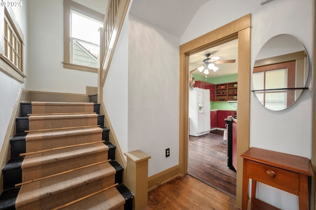 stairs featuring baseboards, a ceiling fan, and wood finished floors