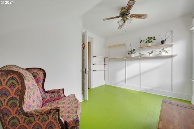 sitting room with baseboards, ceiling fan, and wood finished floors