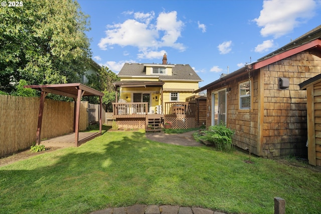 back of house with a deck, a fenced backyard, an outbuilding, a chimney, and a lawn
