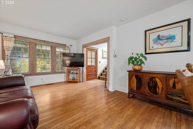 living area with stairway, baseboards, wood finished floors, and visible vents