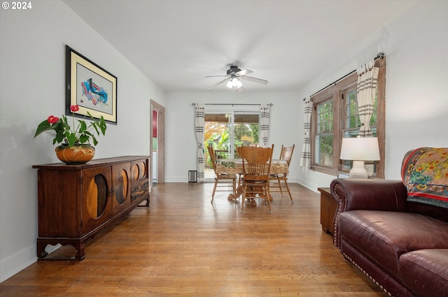 dining room featuring baseboards, a ceiling fan, and light wood-style flooring