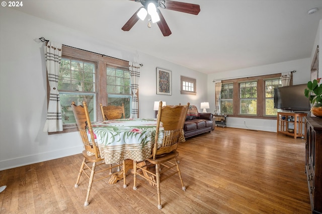 dining space with a ceiling fan, baseboards, and wood finished floors
