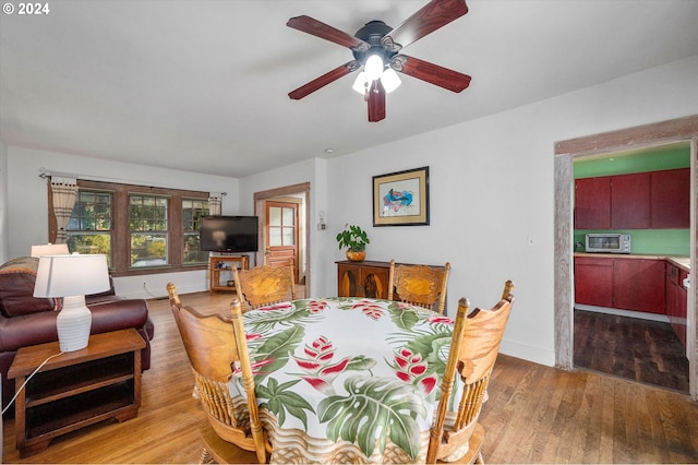 dining area featuring baseboards, a ceiling fan, and wood finished floors