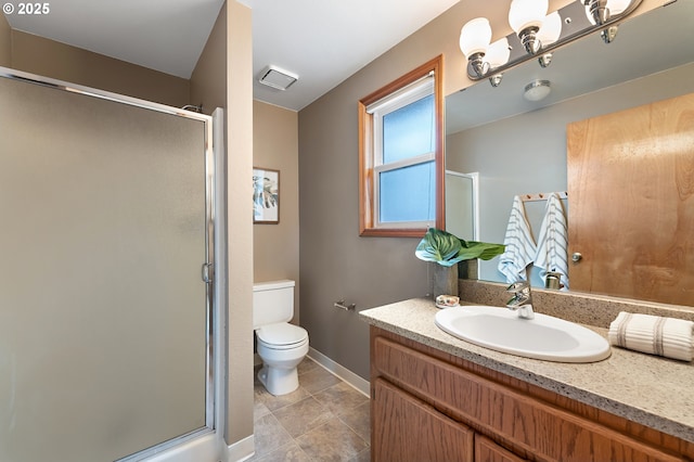 bathroom with vanity, toilet, baseboards, and a stall shower
