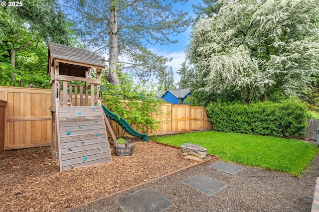 view of playground with a lawn and a fenced backyard