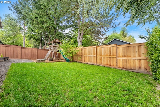 view of yard with a playground and a fenced backyard