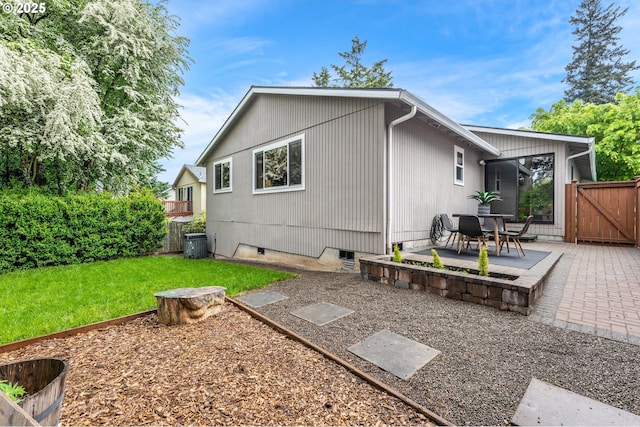 back of property featuring fence, a gate, a patio area, crawl space, and a yard